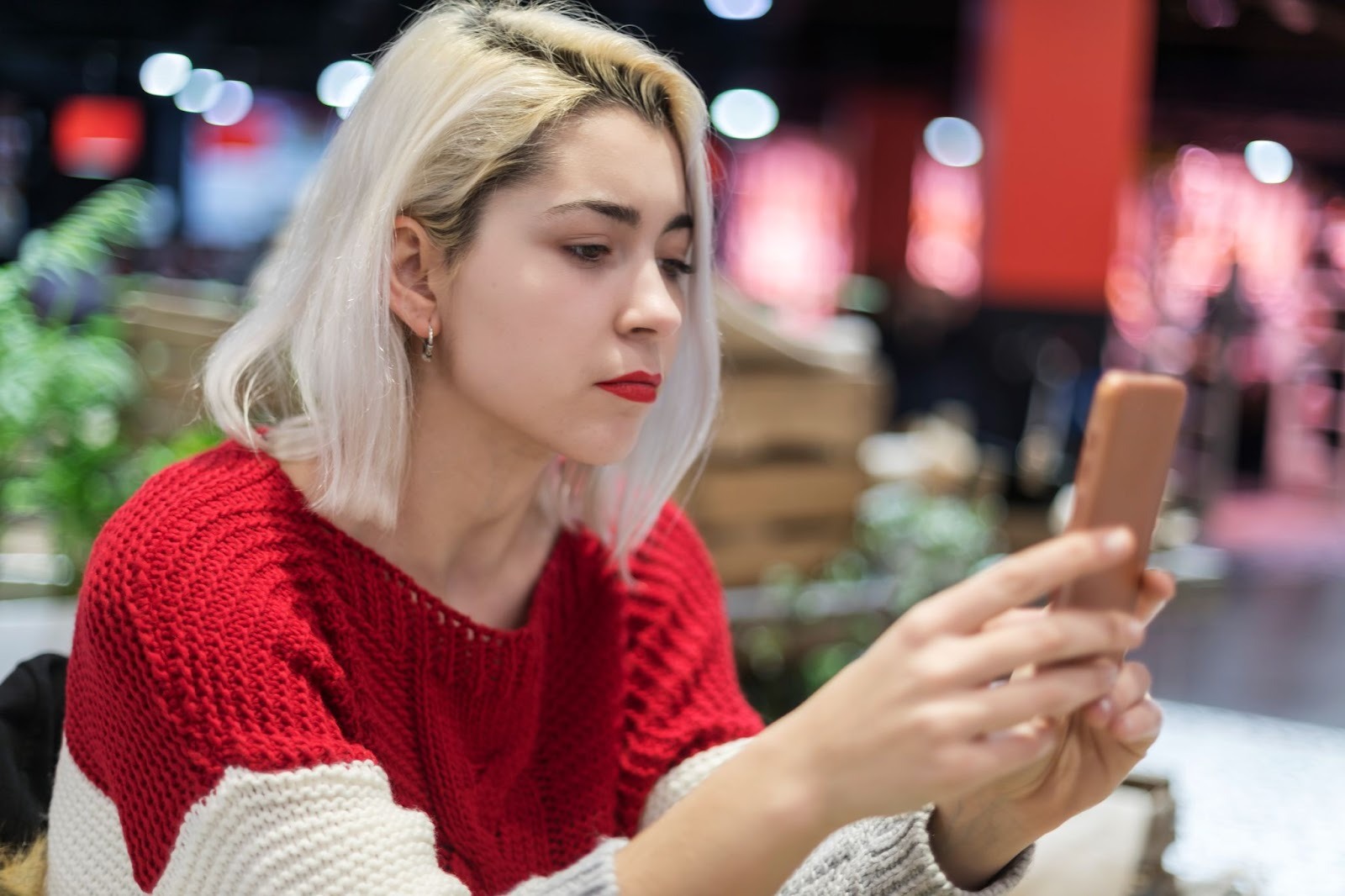 Молодая женщина думает что спросить у парня при переписке в приложении знакомств
