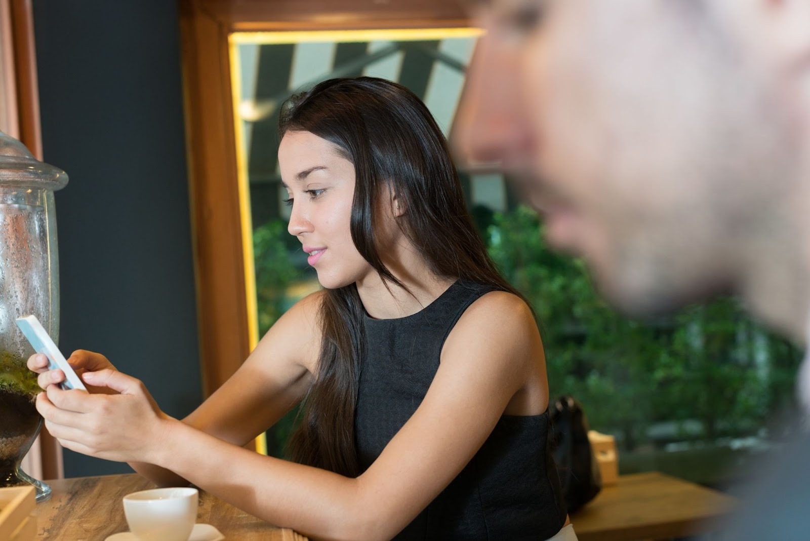 Девушка заполняет анкету на сайте знакомств с улыбкой на лице
