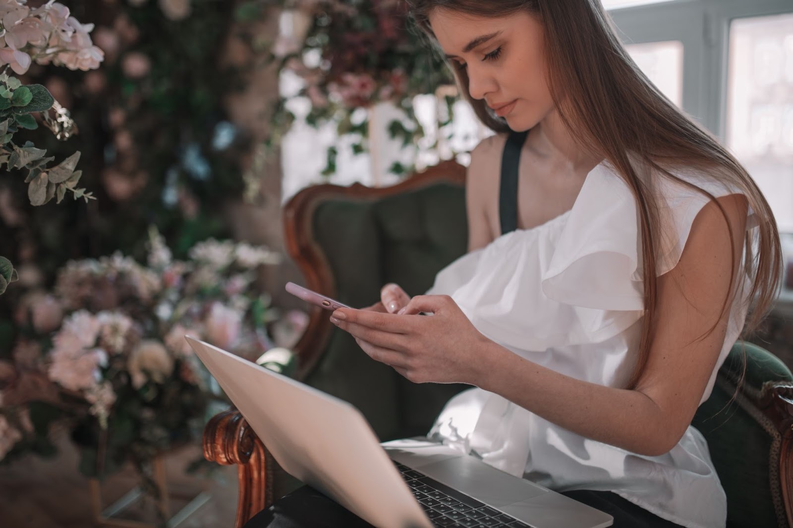 Девушка заполняет анкету на сайте знакомств с улыбкой на лице
