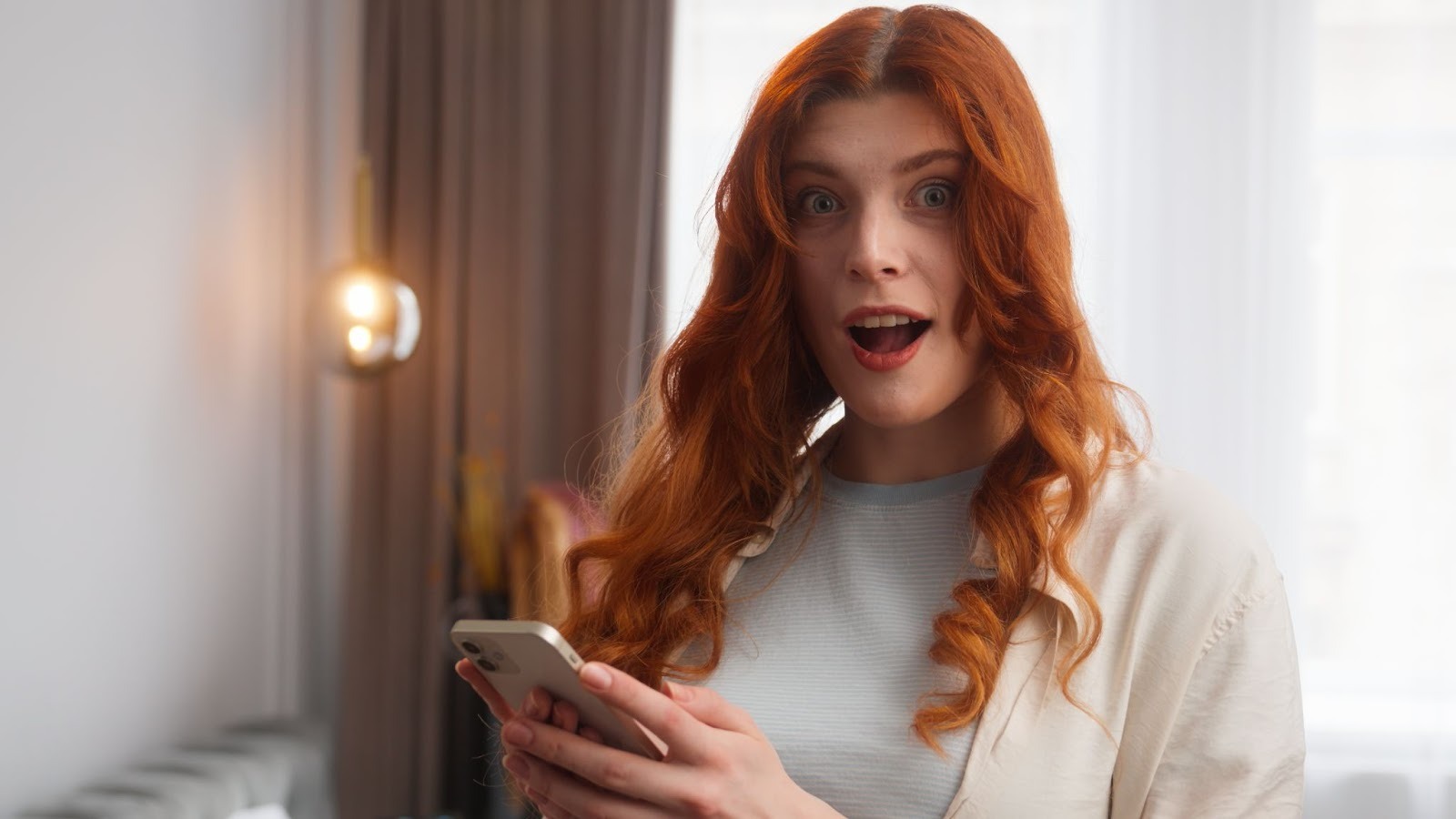 Девушка улыбается читая горячие подкаты от парня в телефоне