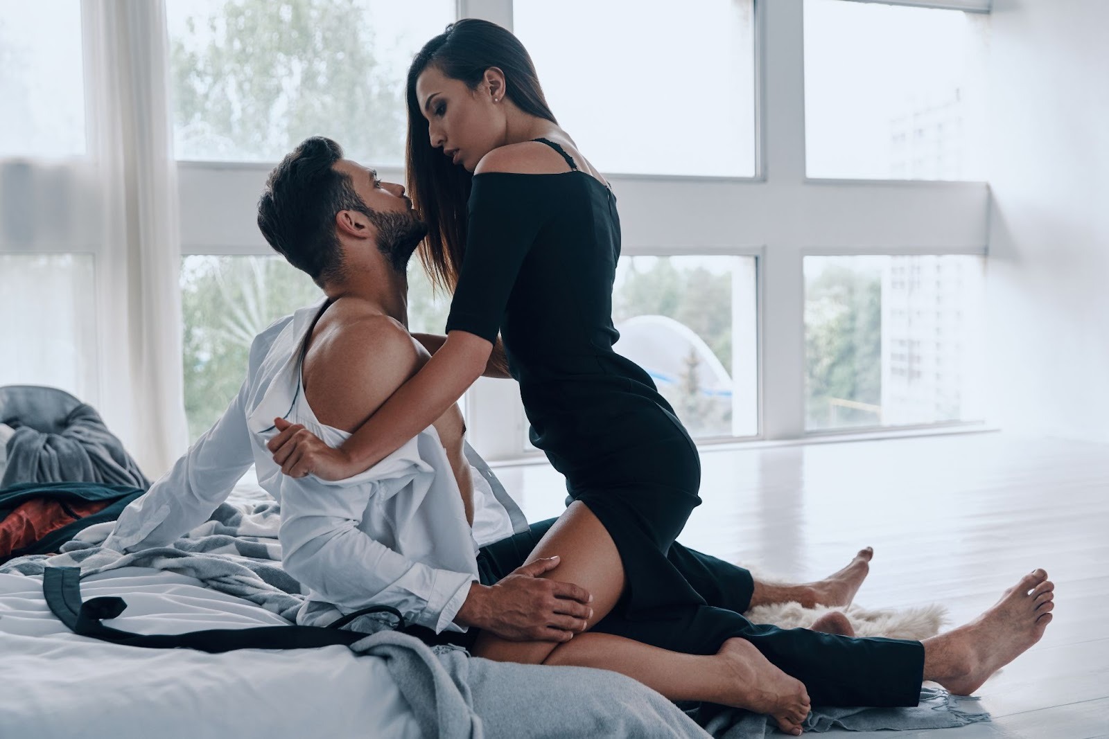 Молодая пара обнимается у окна 