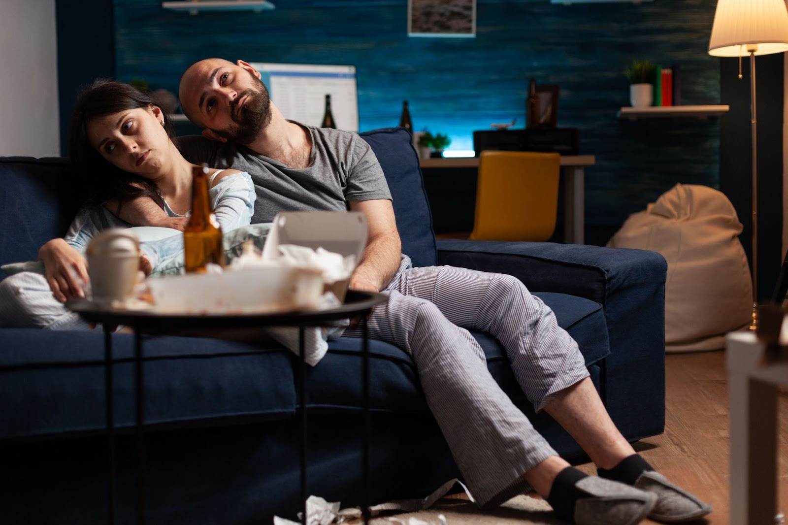 Пара сидит на диване и смотрит в телефоны - пропала страсть в отношениях
